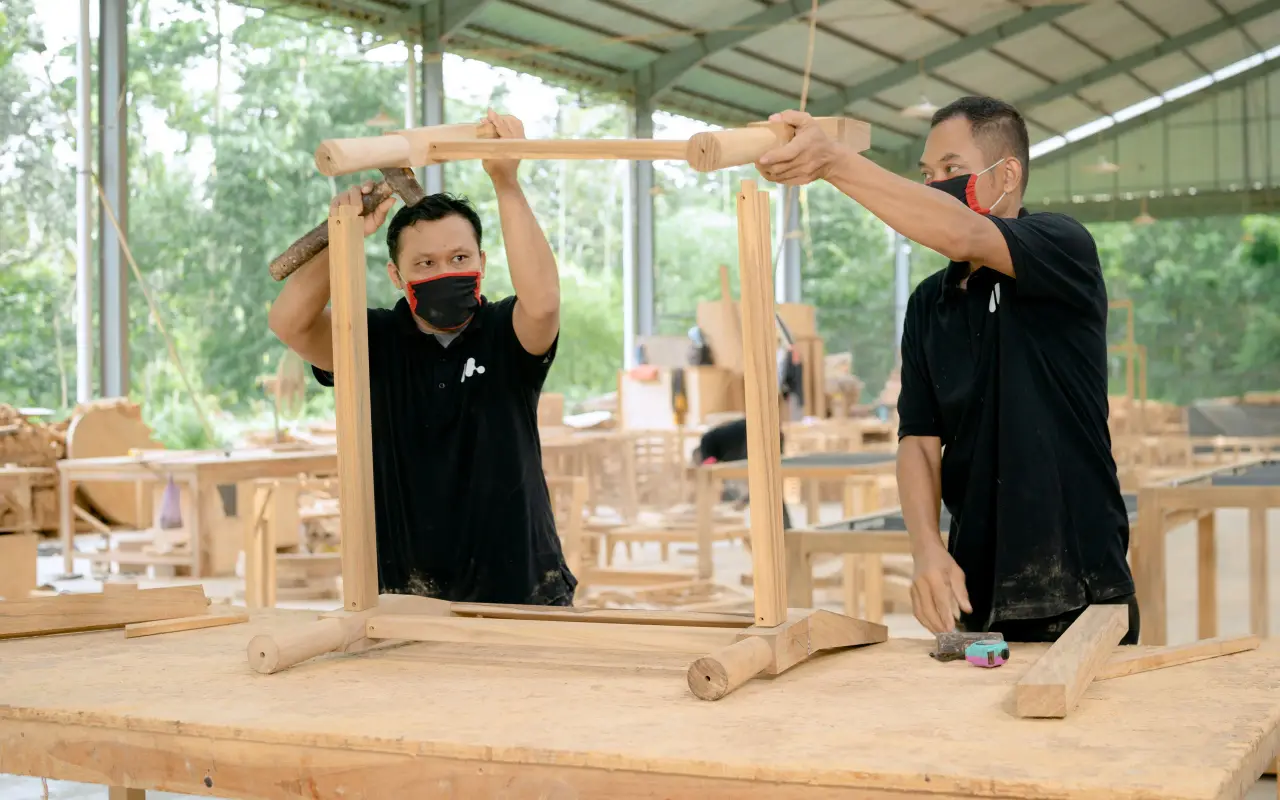Équipe préparant des plans de meubles dans un atelier